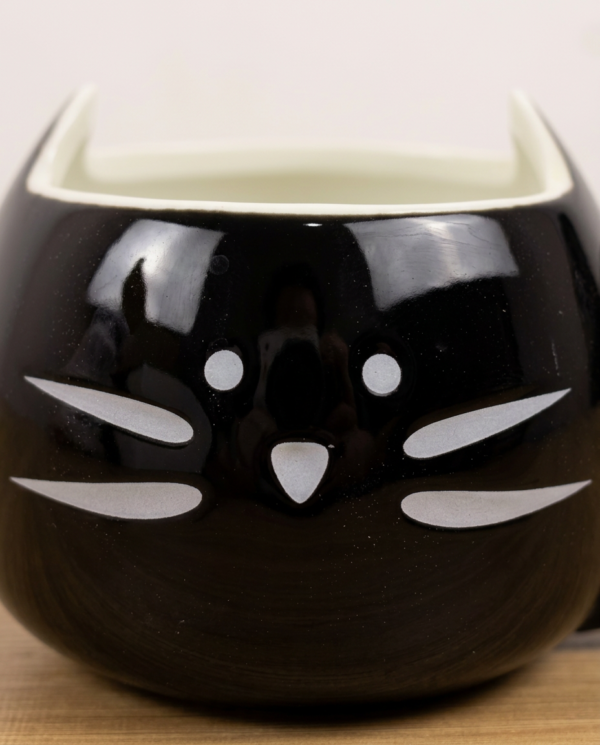 taza negra detalle cara gato